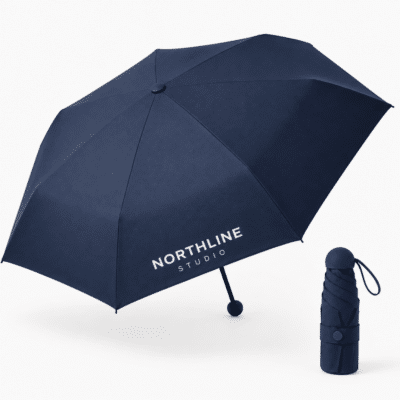 مظلة جيبية زرقاء داكنة مخصصة بشعار NORTHLINE STUDIO أبيض، معروضة مفتوحة بجانب المظلة المطوية