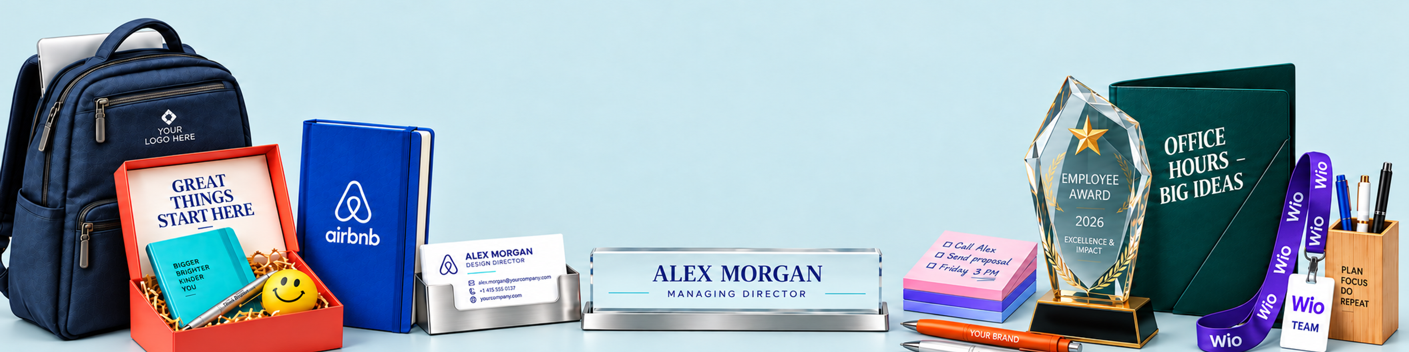 Custom office stationery: laptop backpack, welcome kit, Airbnb notebook, business-card holder, personalised desk nameplate, handwritten sticky notes, Employee Award 2026 trophy, Wio lanyard, and plastic and metal pens